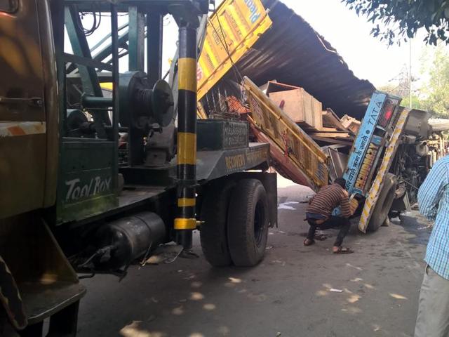 The overturned truck being towed away. The overturned truck being towed away.