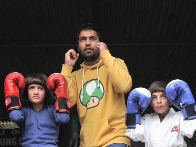 Kickboxers Tajamul Islam (left) and Hashim Peerzada (right) with their coach Faisal Ali at the academy in Bandipora.(Waseem Andrabi/HT Photo) Kickboxers Tajamul Islam (left) and Hashim Peerzada (right) with their coach Faisal Ali at the academy in Bandipora.(Waseem Andrabi/HT Photo)