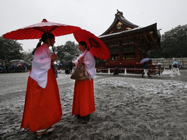 Shrine maidens chat in the snow at the Tsurugaoka Hachimangu Shrine in Kamakura, near Tokyo.(AP Photo/Shizuo Kambayashi) (AP Photo) 