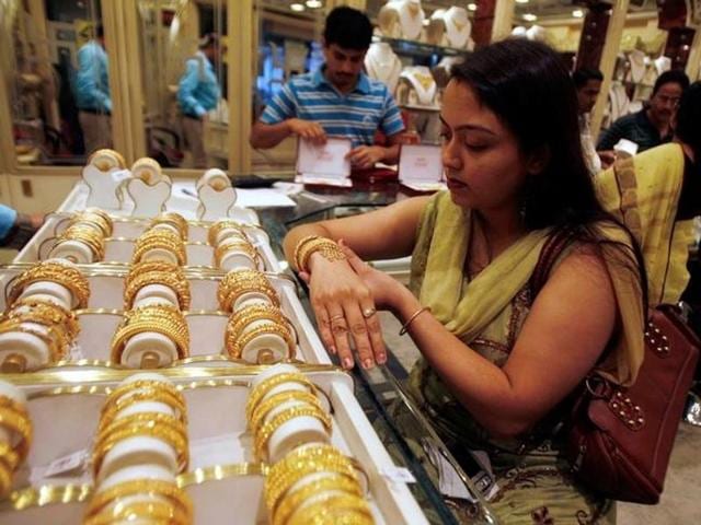 A woman tries on a gold bracelet at a jewellery showroom in the eastern Indian city of Siliguri November 4.(Reuters)