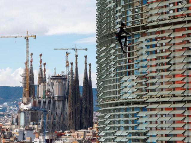 French climber Alain Robert, also known as ‘The French Spiderman’, scales the 38 storey skyscraper Torre Agbar in Barcelona on November 25, 2016. The 19th century Sagrada Familia cathedral, construction for which is yet to be completed, can be seen in the background. (Albert Gea/Reuters) French climber Alain Robert, also known as ‘The French Spiderman’, scales the 38 storey skyscraper Torre Agbar in Barcelona on November 25, 2016. The 19th century Sagrada Familia cathedral, construction for which is yet to be completed, can be seen in the background. (Albert Gea/Reuters)