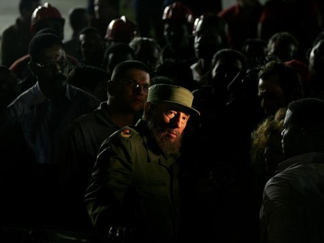 Then Cuban President Fidel Castro looks at a news ticker flashing on the front windows of the U.S. diplomatic mission while visiting the construction site outside the mission in Havana in this January 25, 2006 file photo.  (REUTERS) 
