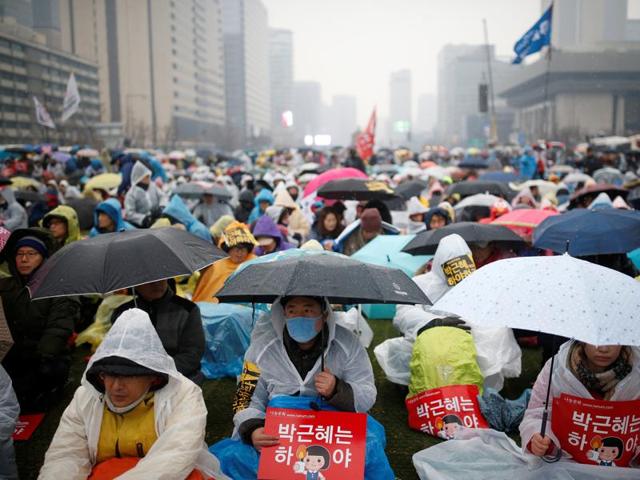 A man carrying his child on his shoulder attends a protest calling for Park Geun-hye to step down in central Seoul. (REUTERS Photo) A man carrying his child on his shoulder attends a protest calling for Park Geun-hye to step down in central Seoul. (REUTERS Photo)