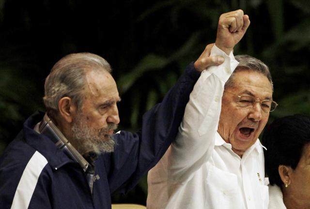 In this April 19, 2011 file photo, Fidel Castro raises his brother Cuba's President Raul Castro's hand as they sing the anthem of international socialism during the 6th Communist Party Congress in Havana, Cuba. (AP)