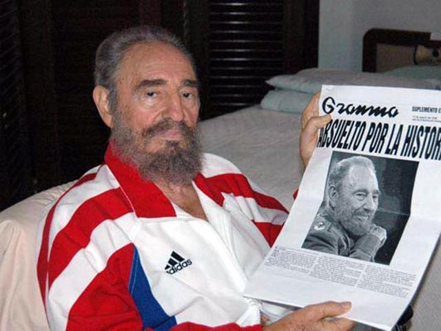 Cuban President Fidel Castro shows a copy of a newspaper in this August 13, 2006 file photo.  (REUTERS) 