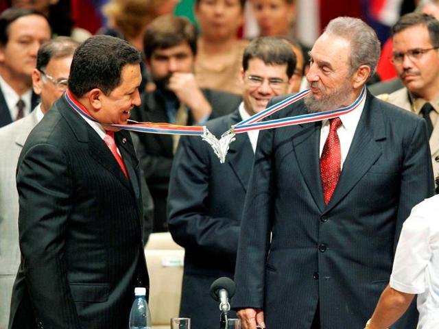 Venezuela's President Hugo Chavez (L) and his Cuban counterpart Fidel Castro joke after joining their medallions, given by medical graduates, at Havana's Karl Marx theatre, in this August 20, 2005 file photo. (REUTERS) 