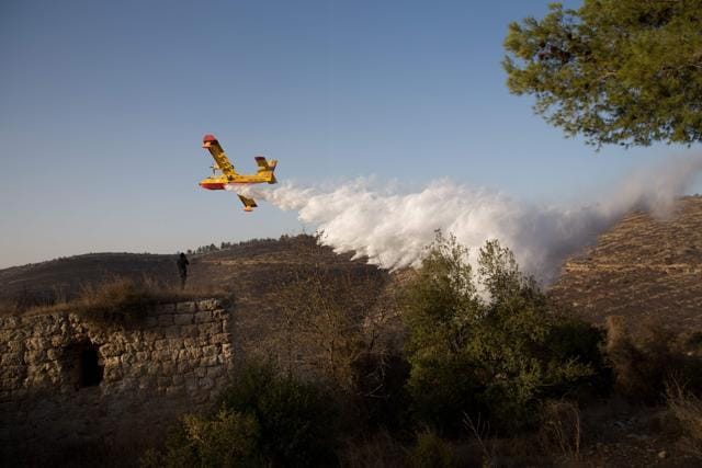 A foreign firefighting plane helps extinguish a fire over the village of Nataf close to Jerusalem, as it helps extinguish an ongoing fire in the area, on November 26, 2016. (AFP) A foreign firefighting plane helps extinguish a fire over the village of Nataf close to Jerusalem, as it helps extinguish an ongoing fire in the area, on November 26, 2016. (AFP)