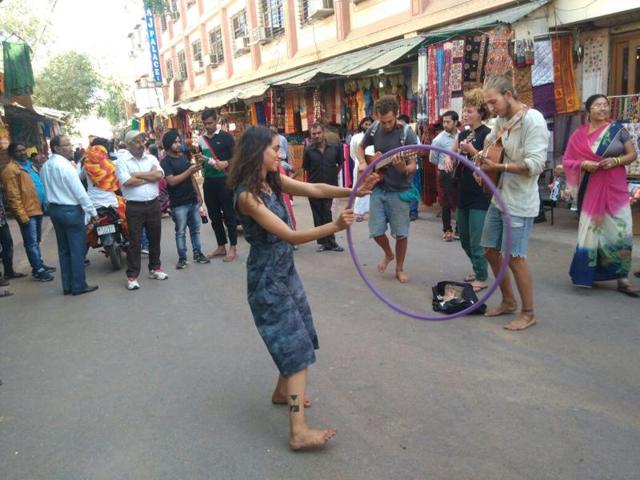 Tourists perform on the streets of Pushkar to raise money for tickets to New Delhi after the demonetisation of high-value currency left them ‘virtually penniless’.(HT Photo)