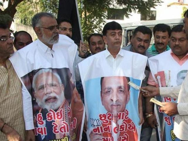 Congress supporters protest against Prime Minister Narendra Modi over the ban on Rs500 and Rs1,000 notes outside Gujarat chief minister Vijay Rupani’s house in Rajkot on Sunday.(PTI)