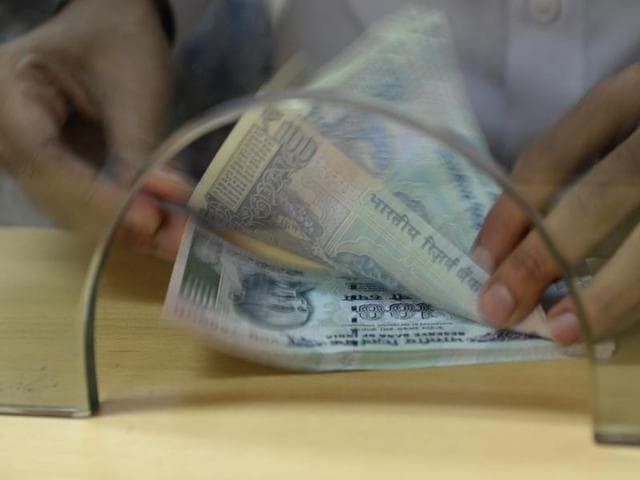 A customer counts Indian 100 rupee currency notes after withdrawing money at a bank on November 24 in Mumbai.(AFP Photo) A customer counts Indian 100 rupee currency notes after withdrawing money at a bank on November 24 in Mumbai.(AFP Photo)