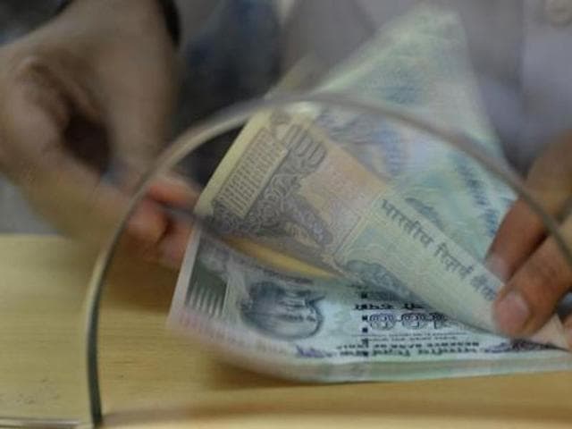 A customer counts Indian 100 rupee currency notes after withdrawing money at a bank, in the wake of the demonetisation of old 500 and 1000 rupee notes in Mumbai.(AFP Photo) A customer counts Indian 100 rupee currency notes after withdrawing money at a bank, in the wake of the demonetisation of old 500 and 1000 rupee notes in Mumbai.(AFP Photo)