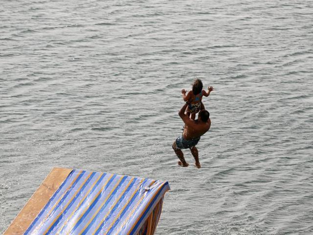 A man carrying his daughter slides down a ramp into the lake in Wadi el-Rayan Fayoum. (REUTERS) A man carrying his daughter slides down a ramp into the lake in Wadi el-Rayan Fayoum. (REUTERS)