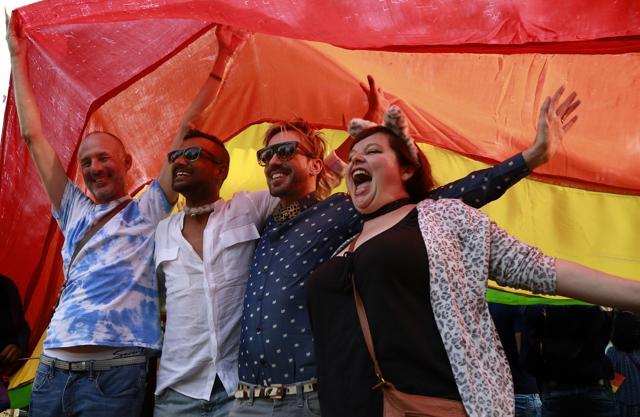 Participants of the ninth annual Delhi Queer pride Parade pose under the rainbow hued flag. (Zabeeh Afaque/HT Photo)