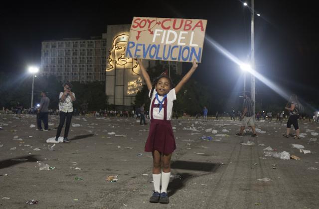 A little girl poses holding a sign that reads in Spanish "I am Cuba. Fidel revolution".  (AP)