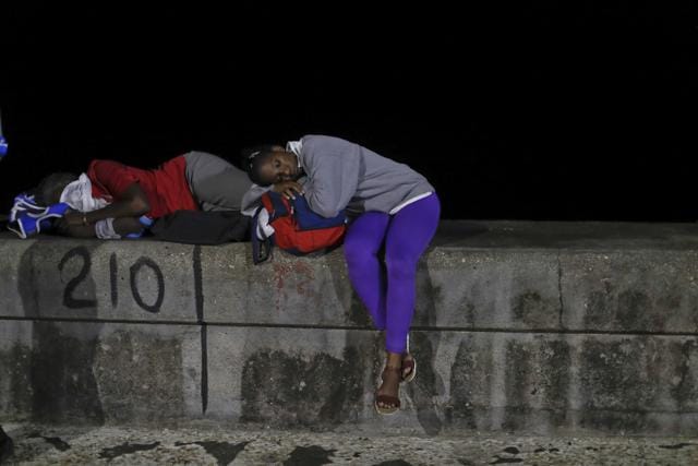 A man and a woman nap on the Malecon seaside front as they wait for the motorcade transporting the remains of Cuban leader Fidel Castro in Havana, Cuba.  (AP)