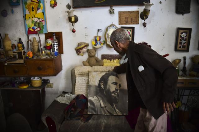A man shows a poster of late Cuban revolutionary leader Fidel Castro at his home in Havana.  (AFP)
