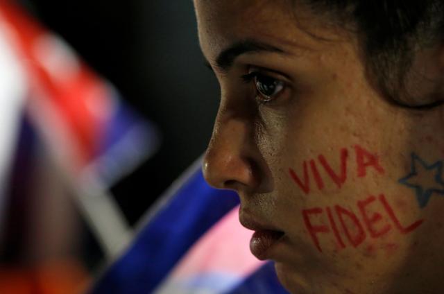 A woman with the writing "Fidel lives" on her cheek.  (REUTERS)