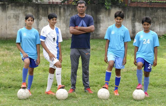The under-14 Sadalpur village girls with their coach Vinod Kumar Loyal. (Karun Sharma/HT)