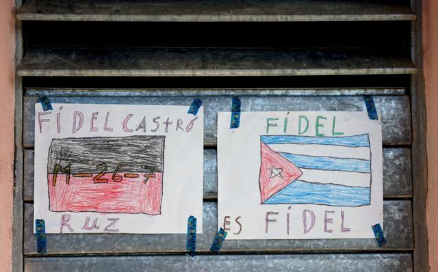 A drawing of the flag of Fidel Castro's Moncada 26-7 revolutionary movement, left, hangs by a Cuban flag on a building along Raul Perozo Avenue, near the cemetery where Fidel Castro's ashes will be buried in Santiago. (AP) A drawing of the flag of Fidel Castro's Moncada 26-7 revolutionary movement, left, hangs by a Cuban flag on a building along Raul Perozo Avenue, near the cemetery where Fidel Castro's ashes will be buried in Santiago. (AP)
