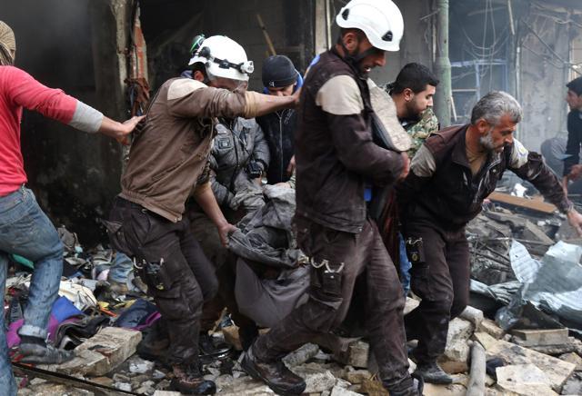 Syrian men and civil defence volunteers help a victim following an air strike on Maaret al-Numan village. (AFP photo) Syrian men and civil defence volunteers help a victim following an air strike on Maaret al-Numan village. (AFP photo)