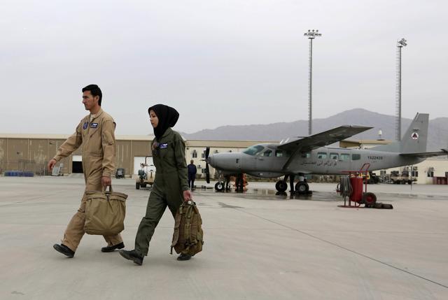 In this Monday, Nov. 21, 2016, photo, Capt. Safia Ferozi, 26, right, and her husband Capt. Mohammad Jawad Najafi, 31, left, walk past a C-208 plane at the Afghan military airbase in Kabul, Afghanistan. (AP) In this Monday, Nov. 21, 2016, photo, Capt. Safia Ferozi, 26, right, and her husband Capt. Mohammad Jawad Najafi, 31, left, walk past a C-208 plane at the Afghan military airbase in Kabul, Afghanistan. (AP)