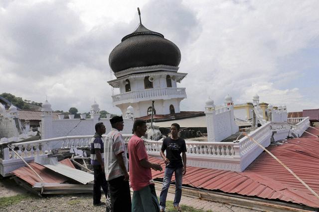 Men inspect a collapsed mosque after an earthquake in Pidie Jaya, Aceh province, Indonesia. (AP)