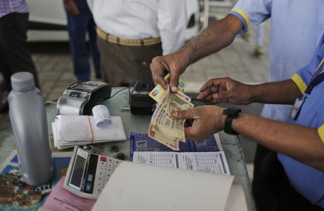 Gas station attendants check 500 and 1000 rupee notes in New Delhi. (AP) Gas station attendants check 500 and 1000 rupee notes in New Delhi. (AP)