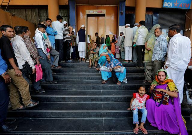 People wait for a bank to open to withdraw and deposit their money, after the scrapping of high denomination 500 and 1,000 Indian rupees currency notes, in Ahmedabad. (Reuters Photo) People wait for a bank to open to withdraw and deposit their money, after the scrapping of high denomination 500 and 1,000 Indian rupees currency notes, in Ahmedabad. (Reuters Photo)