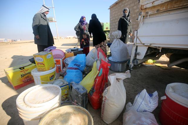 Displaced Iraqi women, from the outskirts of the city of Tal Afar, unload pans and food at a makeshift camp on December 12, 2016 in the village of Khalif Saleh, south of Tal Afar, where they found refuge as Iraqi forces continue their assault to eject Islamic State (IS) group jihadists from Mosul. (AFP Photo) Displaced Iraqi women, from the outskirts of the city of Tal Afar, unload pans and food at a makeshift camp on December 12, 2016 in the village of Khalif Saleh, south of Tal Afar, where they found refuge as Iraqi forces continue their assault to eject Islamic State (IS) group jihadists from Mosul. (AFP Photo)