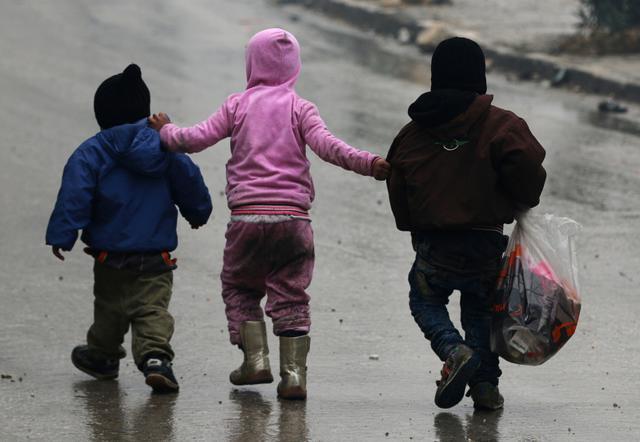 Children walk together as they flee deeper into the remaining rebel-held areas of Aleppo (REUTERS) Children walk together as they flee deeper into the remaining rebel-held areas of Aleppo (REUTERS)