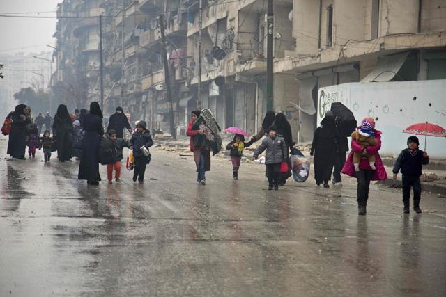 Syrians leave a rebel-held area of Aleppo towards the government-held side on Tuesday during an operation by Syrian government forces to retake the embattled city. (AFP) Syrians leave a rebel-held area of Aleppo towards the government-held side on Tuesday during an operation by Syrian government forces to retake the embattled city. (AFP)