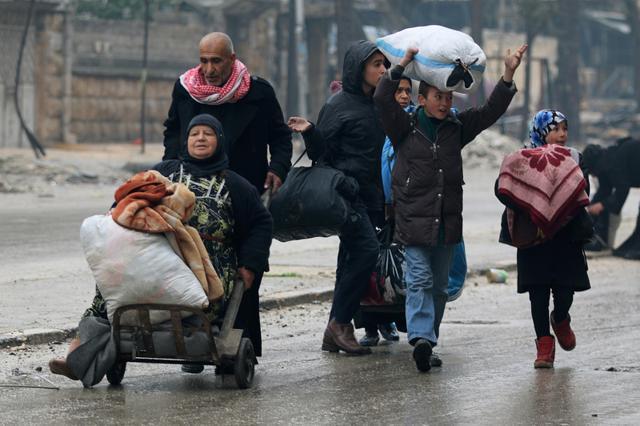 A man pushes a woman on a cart as they flee deeper with others into the remaining rebel-held areas of Aleppo, Syria. (REUTERS)