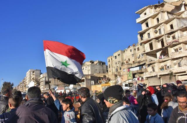A young boy waves the Syrian flag as residents in a government-held area of Aleppo gather in the street during an evacuation operation of rebel fighters and their families from rebel-held neighbourhoods in the embattled Syrian city. (AFP) A young boy waves the Syrian flag as residents in a government-held area of Aleppo gather in the street during an evacuation operation of rebel fighters and their families from rebel-held neighbourhoods in the embattled Syrian city. (AFP)