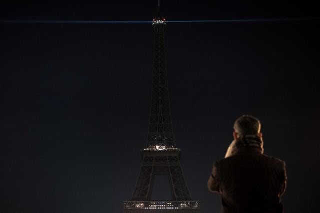 A man takes a picture of the Eiffel Tower. (AFP Photo)
