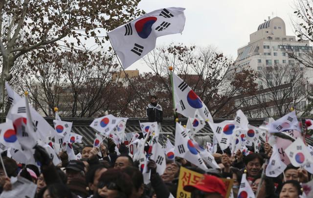 Supporters of impeached South Korean President Park Geun-hye wave their national flags during a rally opposing her impeachment near the Constitutional Court in Seoul, South Korea. (AP Photo) Supporters of impeached South Korean President Park Geun-hye wave their national flags during a rally opposing her impeachment near the Constitutional Court in Seoul, South Korea. (AP Photo)