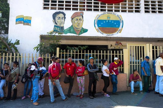 People queue outside Venezuela's Central Bank (BCV), in Caracas, to change 100 Bolivar notes. (AFP Photo) People queue outside Venezuela's Central Bank (BCV), in Caracas, to change 100 Bolivar notes. (AFP Photo)