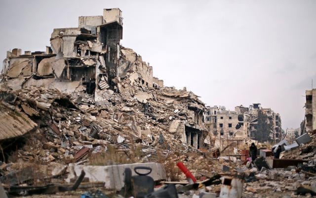 People carry belongings as they walk on the rubble of damaged buildings in the government controlled area of Aleppo. (REUTERS) People carry belongings as they walk on the rubble of damaged buildings in the government controlled area of Aleppo. (REUTERS)