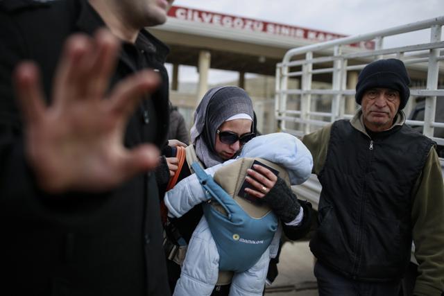A Syrian woman carrying her baby walks after she crossed into Turkey at the Cilvegozu border gate with Syria, near Hatay, southeastern Turkey. (AP Photo) A Syrian woman carrying her baby walks after she crossed into Turkey at the Cilvegozu border gate with Syria, near Hatay, southeastern Turkey. (AP Photo)