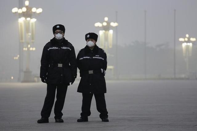 Policemen wear protective masks at the Tiananmen Square on an extremely polluted day as hazardous, choking smog continues to blanket Beijing. (Reuters) Policemen wear protective masks at the Tiananmen Square on an extremely polluted day as hazardous, choking smog continues to blanket Beijing. (Reuters)