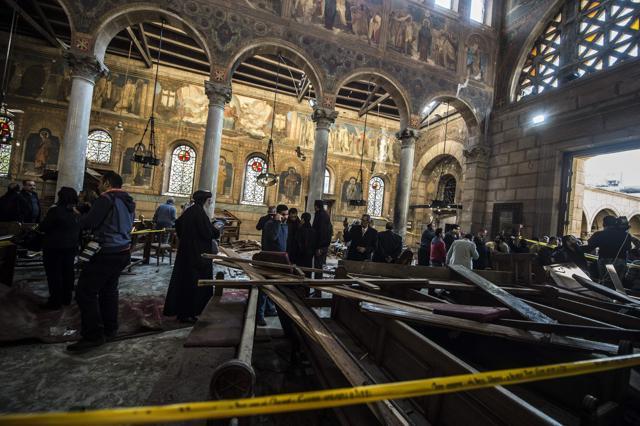 Egypt security forces and members of the clergy inspect the scene of a bomb explosion at the Saint Peter and Saint Paul Coptic Orthodox Church on December 11. (AFP file photo)