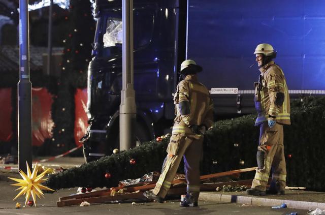 Firefighters look at a toppled Christmas tree after a truck ran into a crowded Christmas market and killed several people in Berlin. (AP) Firefighters look at a toppled Christmas tree after a truck ran into a crowded Christmas market and killed several people in Berlin. (AP)