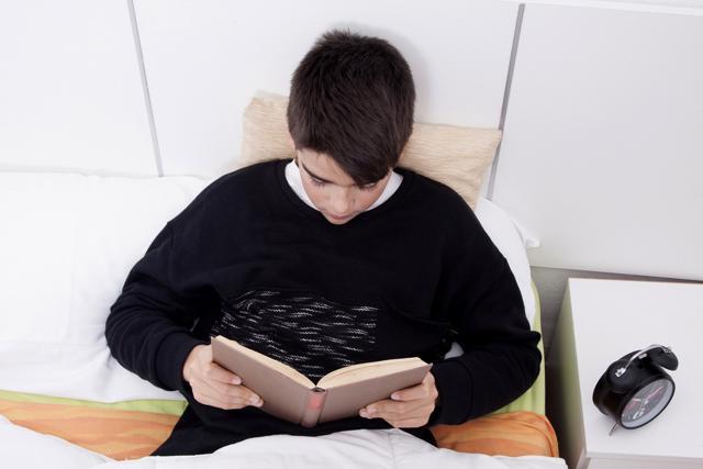 Discourage your kid from lying on bed and reading. (Shutterstock)