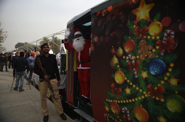 A man dressed as Santa Claus waves from a Christmas-themed train after its inauguration ceremony in Islamabad. (AFP) A man dressed as Santa Claus waves from a Christmas-themed train after its inauguration ceremony in Islamabad. (AFP)