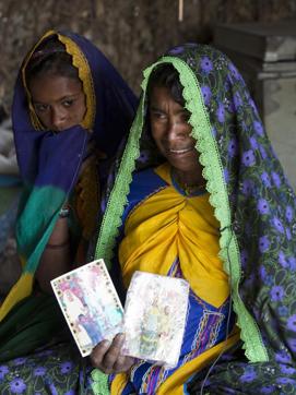 In this photo taken on December 1, Ameri Kashi Kolhi, right, remembers her daughter while holding pictures of Jeevti with her younger daughter Saveeta in Mir Pur Khas, Pakistan. (AP) In this photo taken on December 1, Ameri Kashi Kolhi, right, remembers her daughter while holding pictures of Jeevti with her younger daughter Saveeta in Mir Pur Khas, Pakistan. (AP)