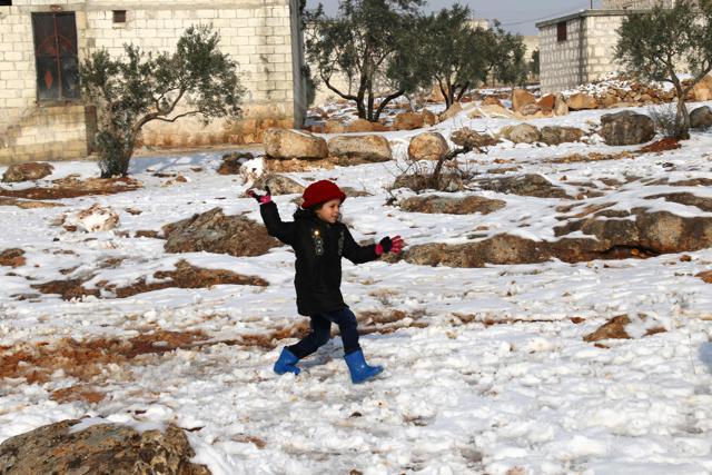 A Syrian child plays in the snow after her family arrived from the rebel-held pockets of Syria's northen city of Aleppo to the opposition-controlled Khan al-Assal region, west of the embattled city. (AFP Photo) A Syrian child plays in the snow after her family arrived from the rebel-held pockets of Syria's northen city of Aleppo to the opposition-controlled Khan al-Assal region, west of the embattled city. (AFP Photo)