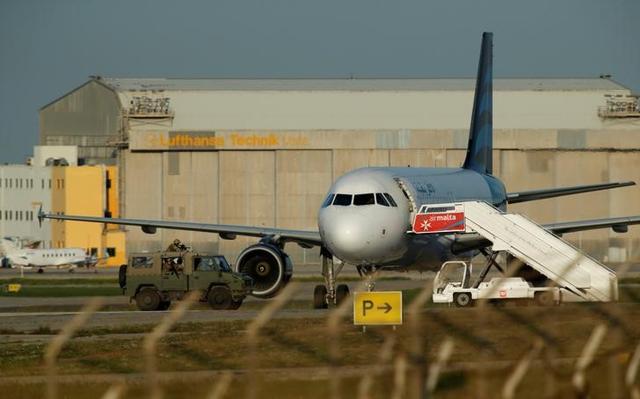 Maltese special forces soldiers approach a hijacked Libyan Afriqiyah Airways Airbus A320 on the runway at Malta International Airport. Maltese special forces soldiers approach a hijacked Libyan Afriqiyah Airways Airbus A320 on the runway at Malta International Airport.
