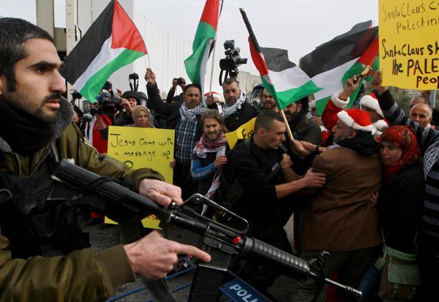 Israeli security forces scuffle with Palestinian protesters, some dressed up as Santa Claus, during a demonstration next to a gate of a section of Israel's separation wall in the biblical town of Bethlehem, in the occupied West Bank. (AFP) Israeli security forces scuffle with Palestinian protesters, some dressed up as Santa Claus, during a demonstration next to a gate of a section of Israel's separation wall in the biblical town of Bethlehem, in the occupied West Bank. (AFP)