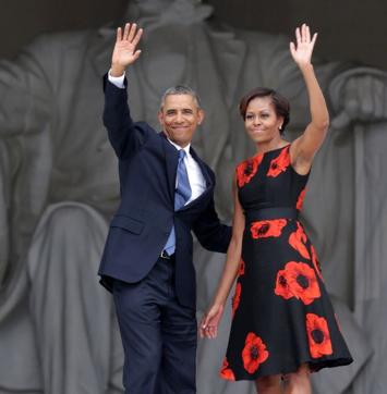 Michelle Obama wearing Tracy Reese’s black dress printed with bright red flowers at an event to commemorate the 50th anniversary of the March on Washington.
