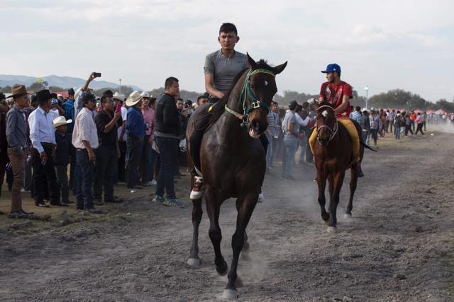 Horsemen take part in a race during Rubi’s birthday celebrations in Miguel Hidalgo, San Luis Potosi State. However, tragedy marred the race as two people entered the track and were hit by the horses. One of them died and the other was hospitalized with a broken leg, the state of San Luis de Potosi said. (AFP)