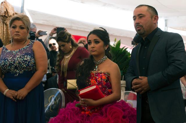 Rubi Ibarra (centre) with her father Cresencio (right) and mother Anaelda during mass in La Joya, San Luis Potosi State, Mexico. The religious ceremony was the start of a long birthday party for the 15-year-old which saw thousands turn up in response to an open invite from Cresencio. (AFP)